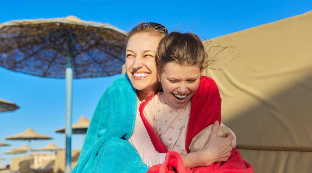 Mama z córka w ręcznikach na plaży