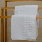 Ręcznik biały Larisa na drewnianym wieszaku